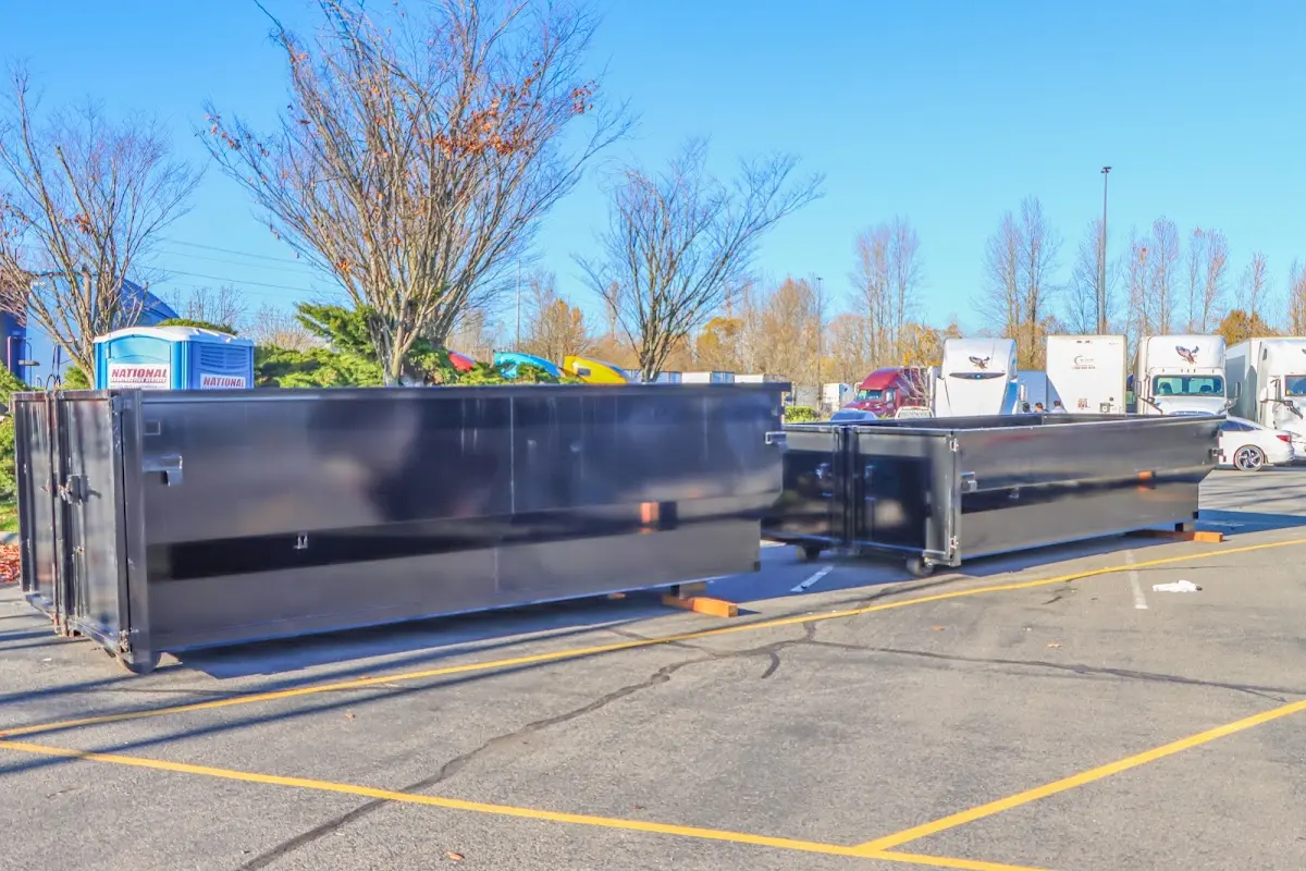 Professional dumpster rental service with roll-off container on residential driveway in Harvey